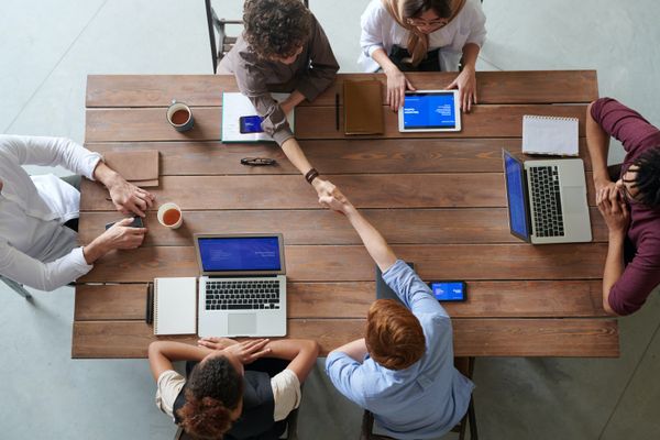 People meeting around a table with wireless devices