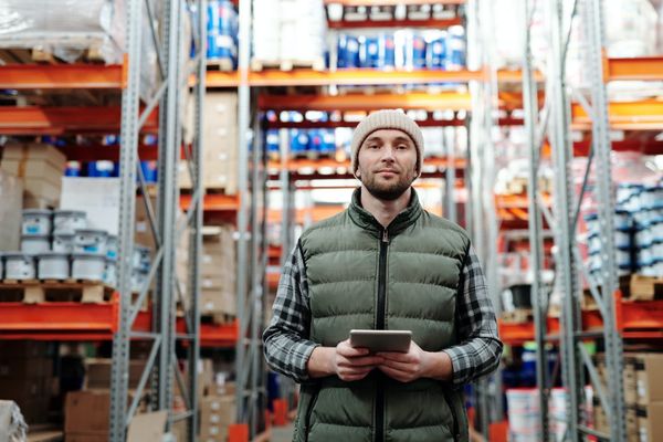 Man stood holding a tablet computer in a warehouse